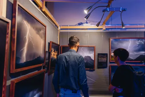 Exposition immersive : visiteurs devant de grands tirages encadrés d’éclairs.