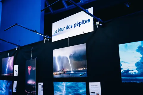 Le Mur des pépites : photographies d’éclairs, de trombes et d’orages sous une lumière bleue.