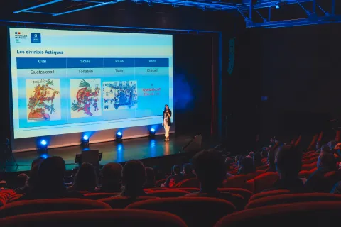 Conférence sur les divinités aztèques du ciel et de la pluie, projetée devant la salle de spectacle.