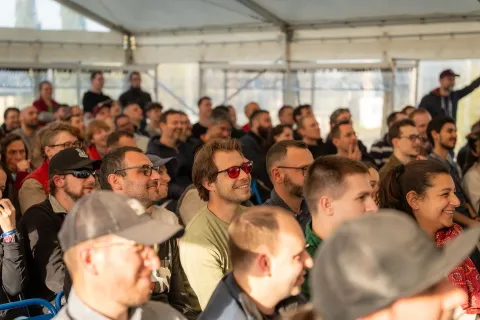 Public attentif et souriant sous la tente des conférences.