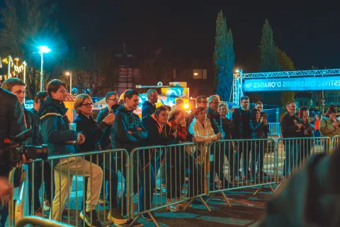 Spectateurs massés derrière les barrières, le soir, devant l’arche du Festival.