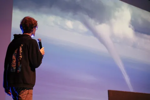 Un spectateur pose sa question au micro devant la projection d’une tornade.